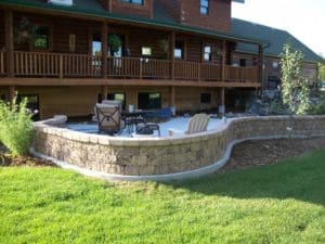 A stone patio paved and created by by Total Lawn Care & Landscape in Sterling, CO in front of a grassy lawn